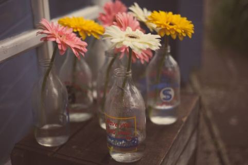 gerbera wedding flowers in vintage milk bottles © - Christy Blanch Photography / French Wedding Style Blog