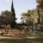 Outdoor grass wedding ceremony set up with trees in background