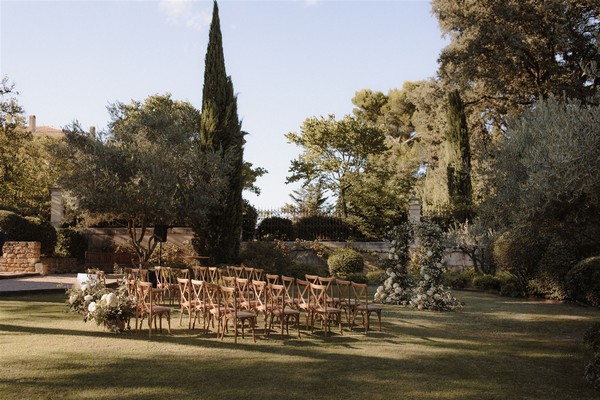 Outdoor grass wedding ceremony set up with trees in background