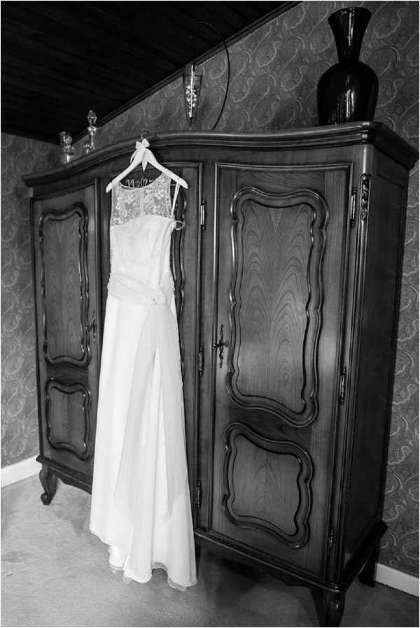 Bridal gown with bow detail hanging on wardrobe