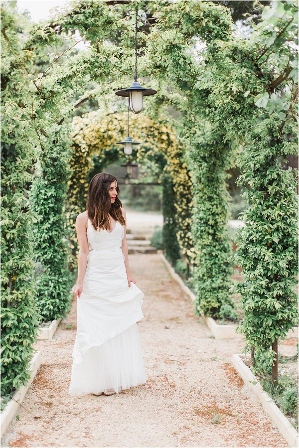 Bride poses under a wonderful flower arch in Provence