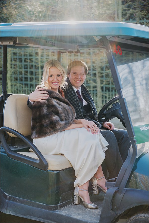 Bride and Groom pose on a golf buggy