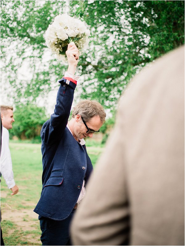 Delighted male wedding guest catches the bouquet