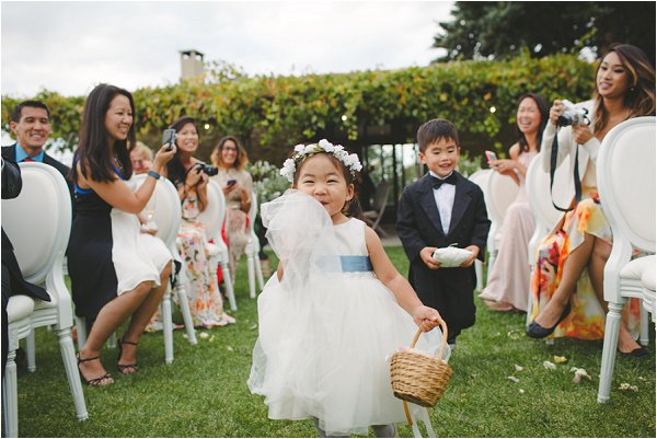 Adorable flower girl and page boy walking down the aisle
