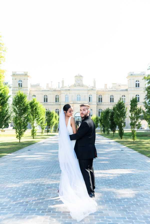 Couple Look Back at Camera Outside Chateau Rothschild in Paris