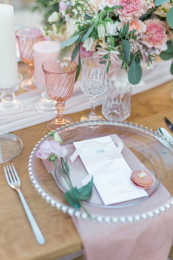 Pastel wedding table setting with pink champagne flutes