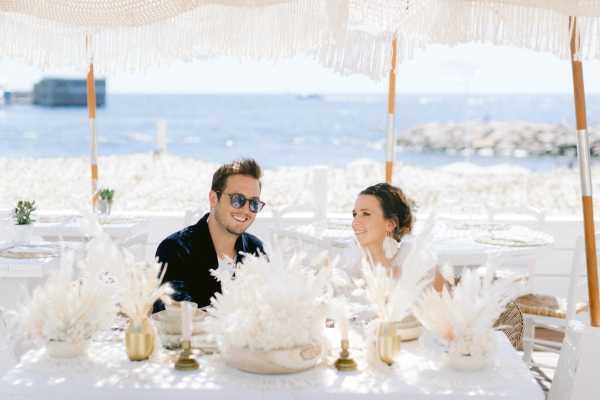 Greek Wedding in Naos Beach France Bride and Groom at Wedding Table