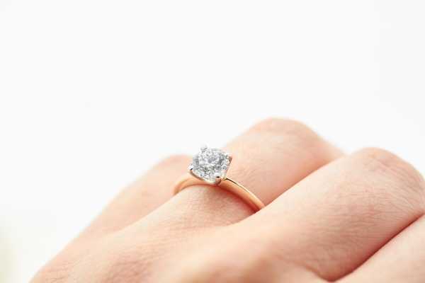 Rose gold and diamond engagement ring on woman's hand by Taylor & Hart