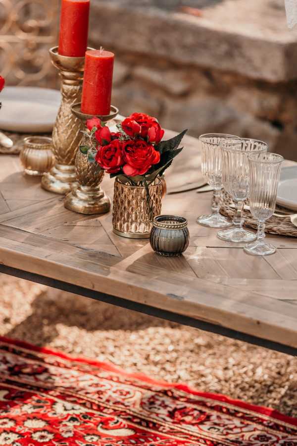 Red flowers and antique rug at asian themed wedding