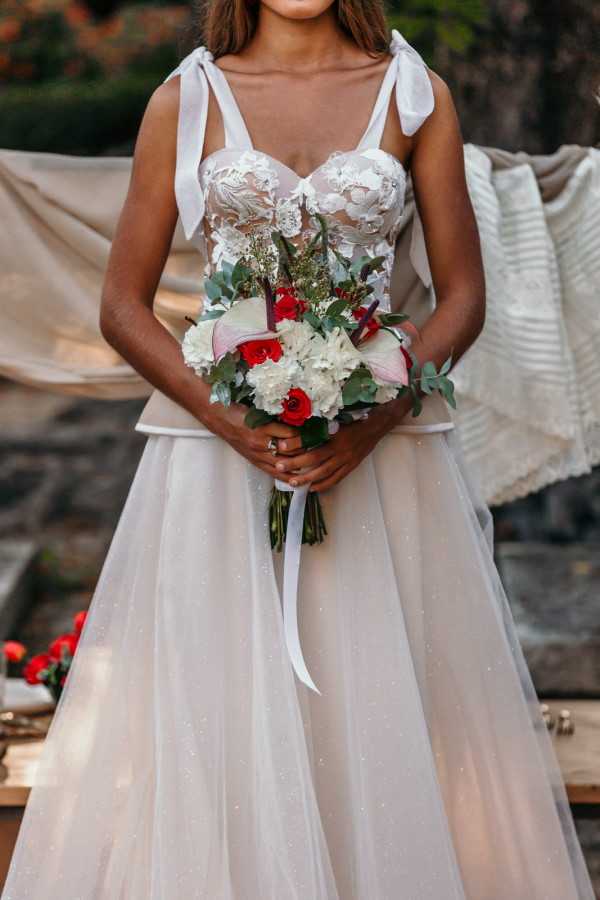 Closeup of bride holding red and white bouquet Bastide du Roy France