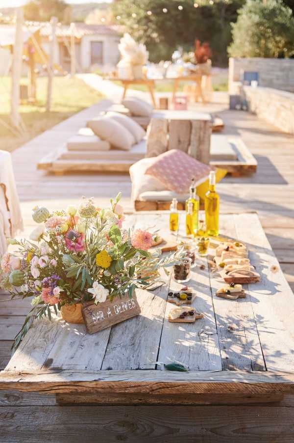 Wooden wedding placard and floral arrangement on rustic wooden table