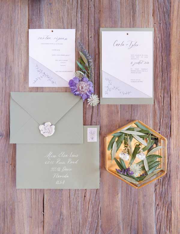 Wedding stationery in pastel green on rustic brown wooden table