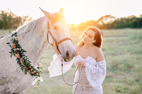 Bride with grey horse wearing floral garland