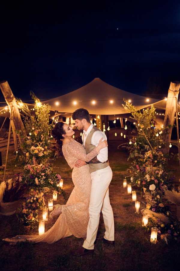 Wedding Tents in the Lavender Meadows of Domaine de Bres couple kiss under festoon lights