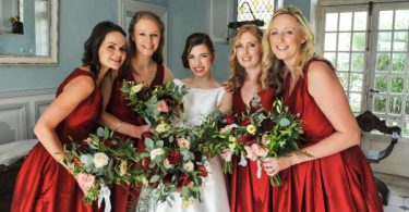 Bride with red lipstick and bridesmaids in red dresses for winter wedding