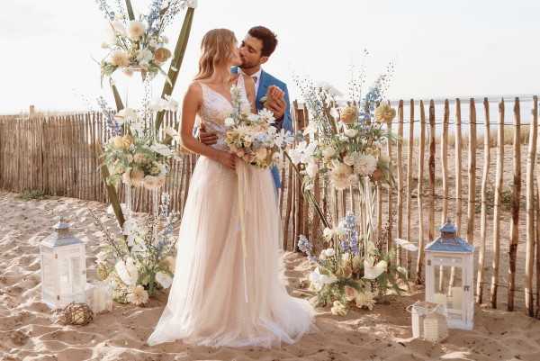 Sea side wedding ceremony in sunlight in sparkling gown and seafoam suit