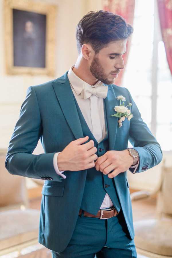 Groom gets ready and puts on blue suit jacket