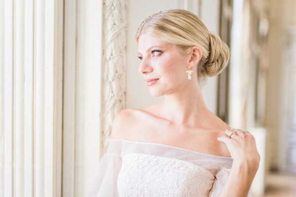 Close up of bride with hair in bun and off shoulder white dress