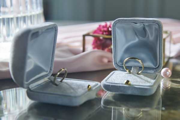 his and hers wedding rings in light blue cushion boxes