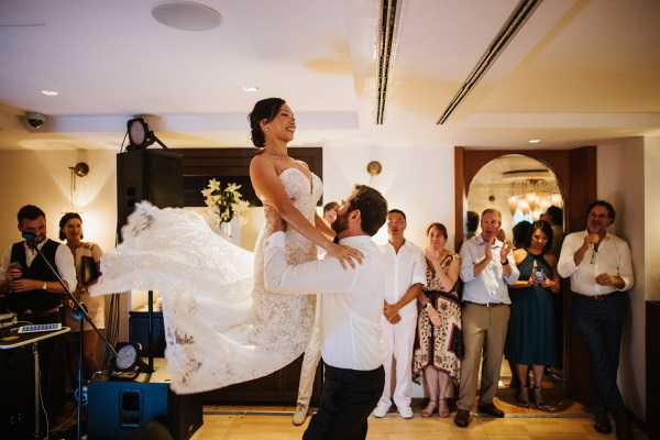 Groom lifts bride into the air as they take their first dance