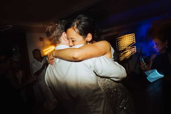 Bride and groom hug in the last moments of their wedding in going away outfits