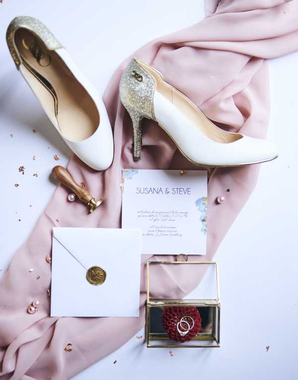 flatlay of diamante encrusted bridal shoes and wedding stationery