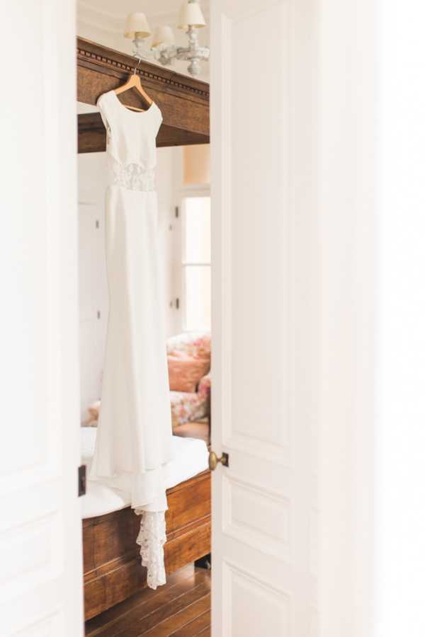 White and lace wedding dress hanging in doorway