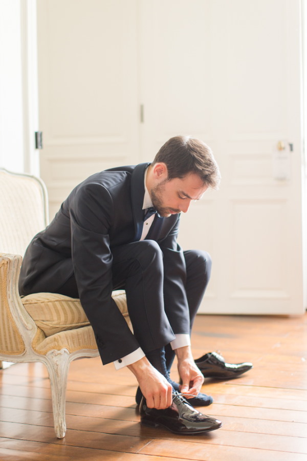 Groom tying shoes before wedding ceremony