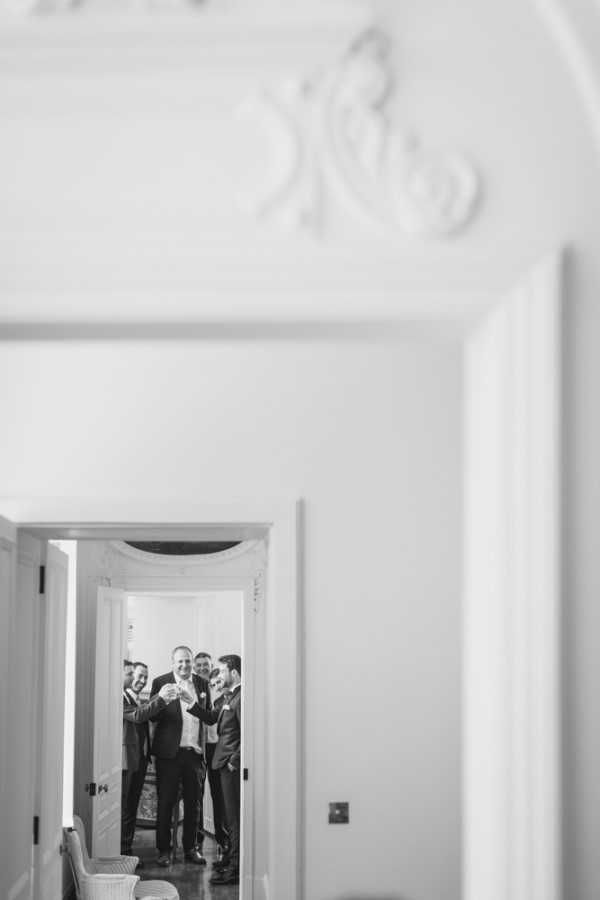 Groom and groomsmen in room at the end of the hall