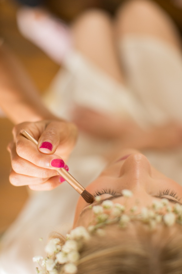 Image taken from above of bride having makeup done