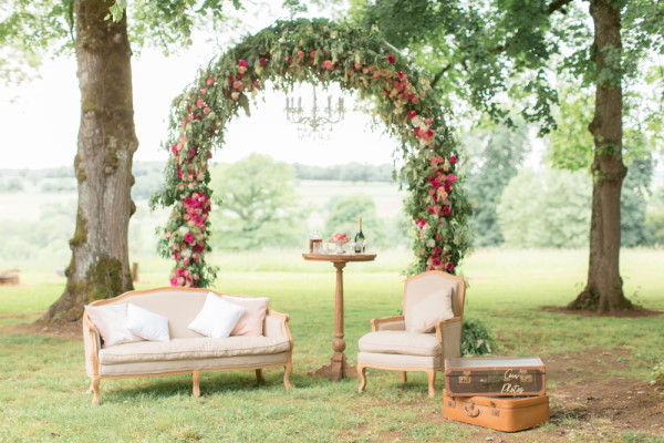 Floral arbor and comfortable lounging chairs in the garden for wedding at Chateau d'Azy
