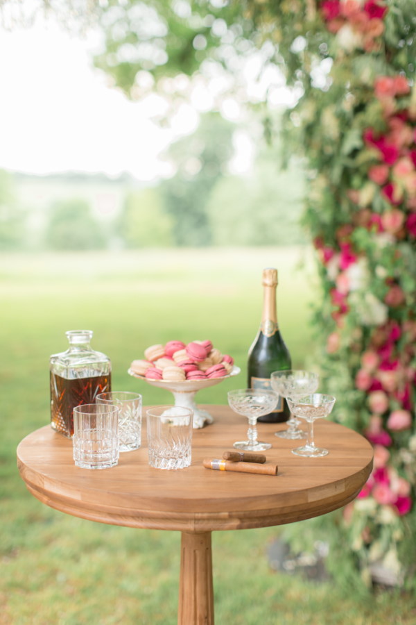 Small table with champagne and pink macarons for wedding guests