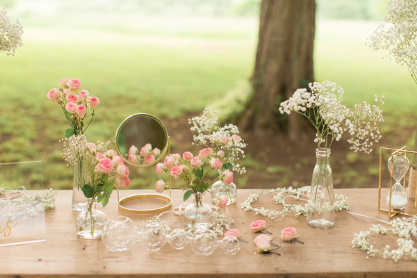 Small flower posies adorn the wedding bar in the garden on old wooden table
