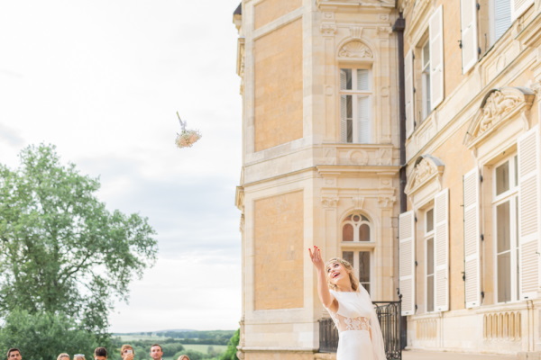 Bride throws her bouquet outside Chateau d'Azy