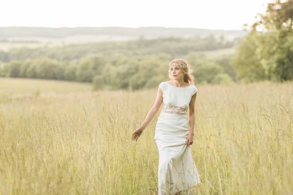 Bride walks through the fields in the grounds of Chateau d'Azy