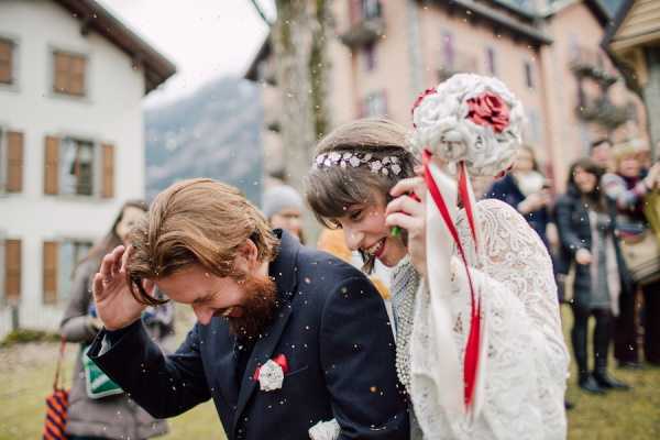 Bride and groom duck as they are showered in sustainable confetti made from birdseed