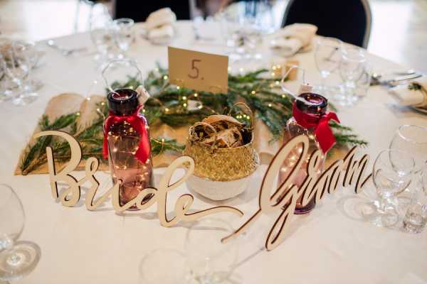 Wedding table decoration that has wooden bride and from signs and branches from nature