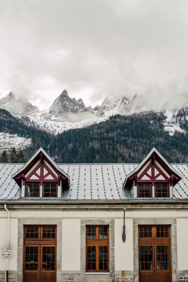 French Alps Chalet Hotel with snowy mountains behind it