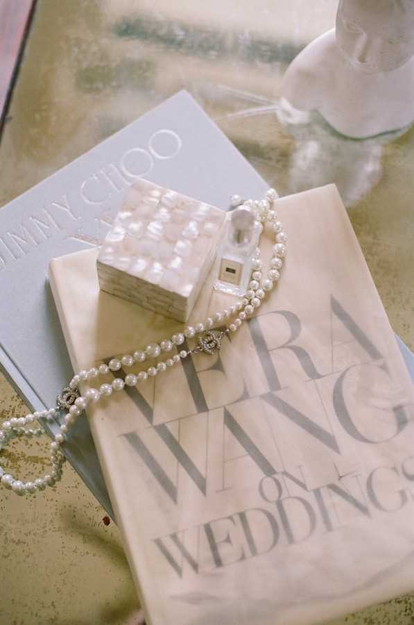 flat lay of Vera Wang "On Weddings" book and pearl necklace