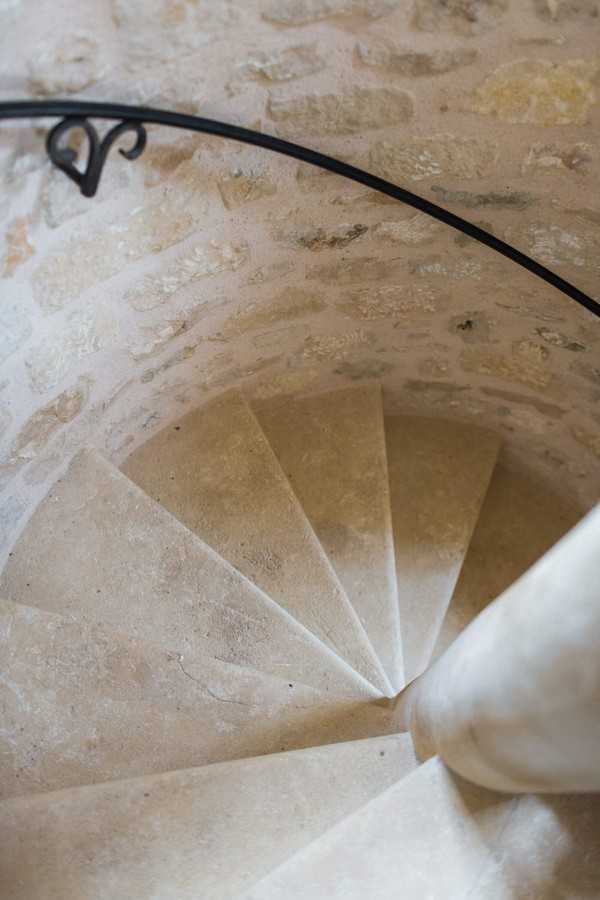 stone spiral staircase with black iron hand railing