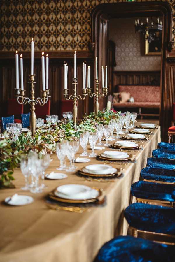 royal blue and gold wedding table setting inside chateau challain with candelabras