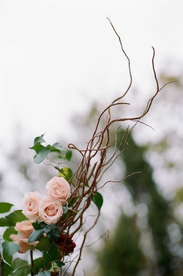 floral detail of wedding arch with brown decorative twigs