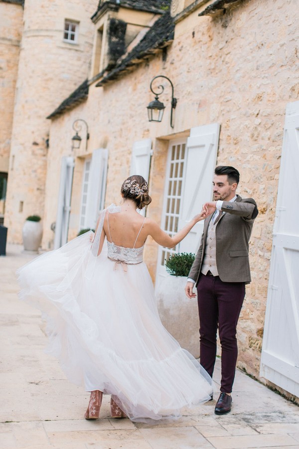 groom spins bride in dance outside Château la Carrière