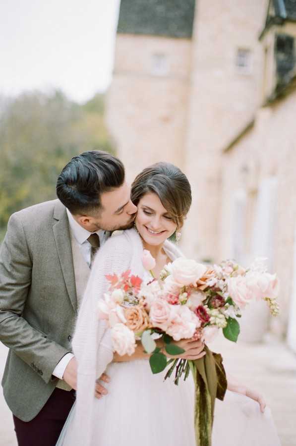 bride and groom kiss with Château la Carrière in background