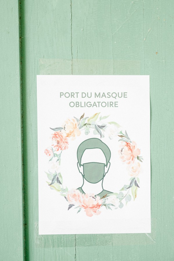 Sign on green door reads "Port du Masque Obligatoire"