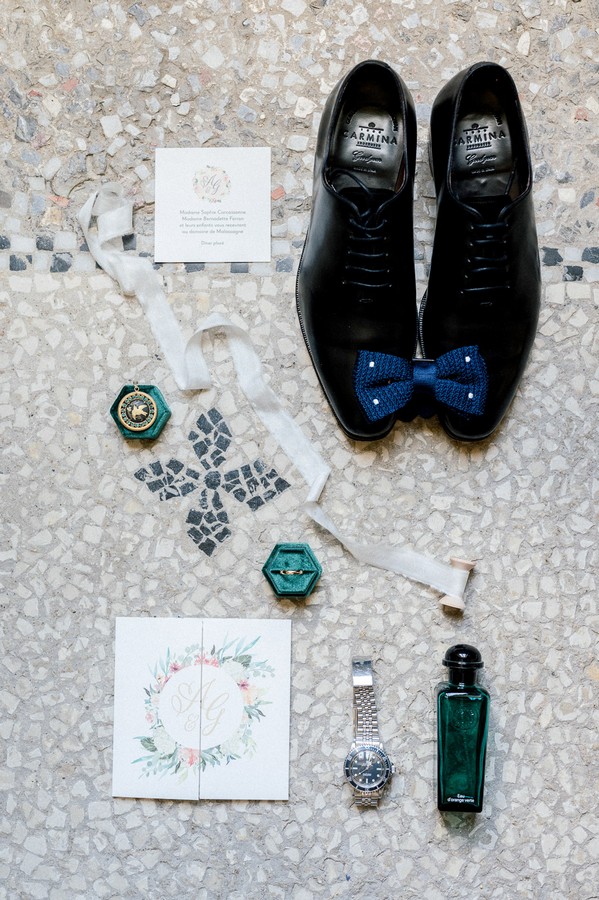 Flat lay of grooms shoes, blue bow tie, rolex and cologne