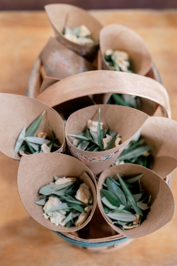 Brown paper cones filled with dried leaves and flowers for confetti
