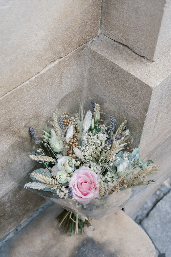 Pastel bunch of flowers leans against sandstone wall