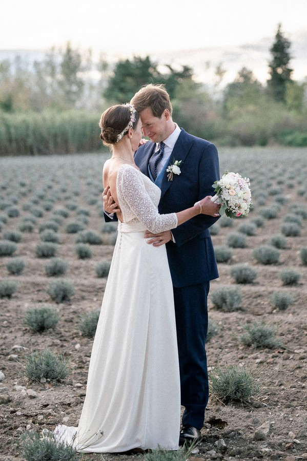 Bride and groom look into each other's eyes in field