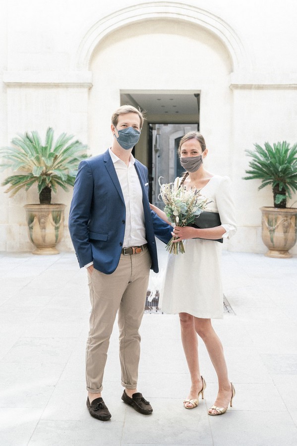 Bride and groom wearing grey facemasks for wedding ceremony